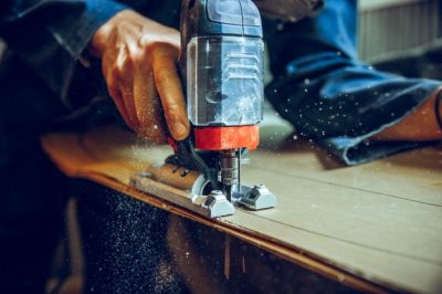 carpenter-using-circular-saw-cutting-wooden-boards-construction-details-male-worker-handy-man-with-power-tools_155003-18447