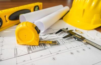 construction-plans-with-yellow-helmet-drawing-tools-bluep_1232-2940